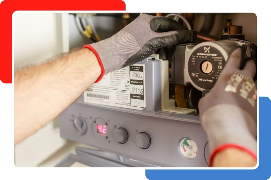 A close-up of a technician's gloved hands installing or repairing a circular pump component on a gray boiler unit.